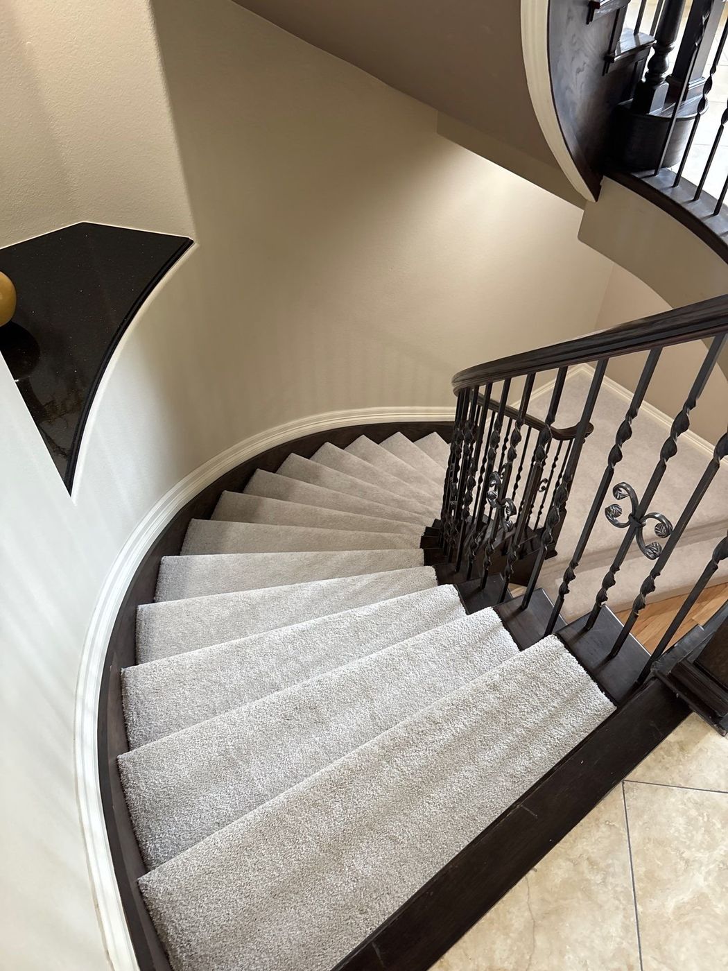 The curve of a staircase in Lone Tree with new carpet, seen from the top